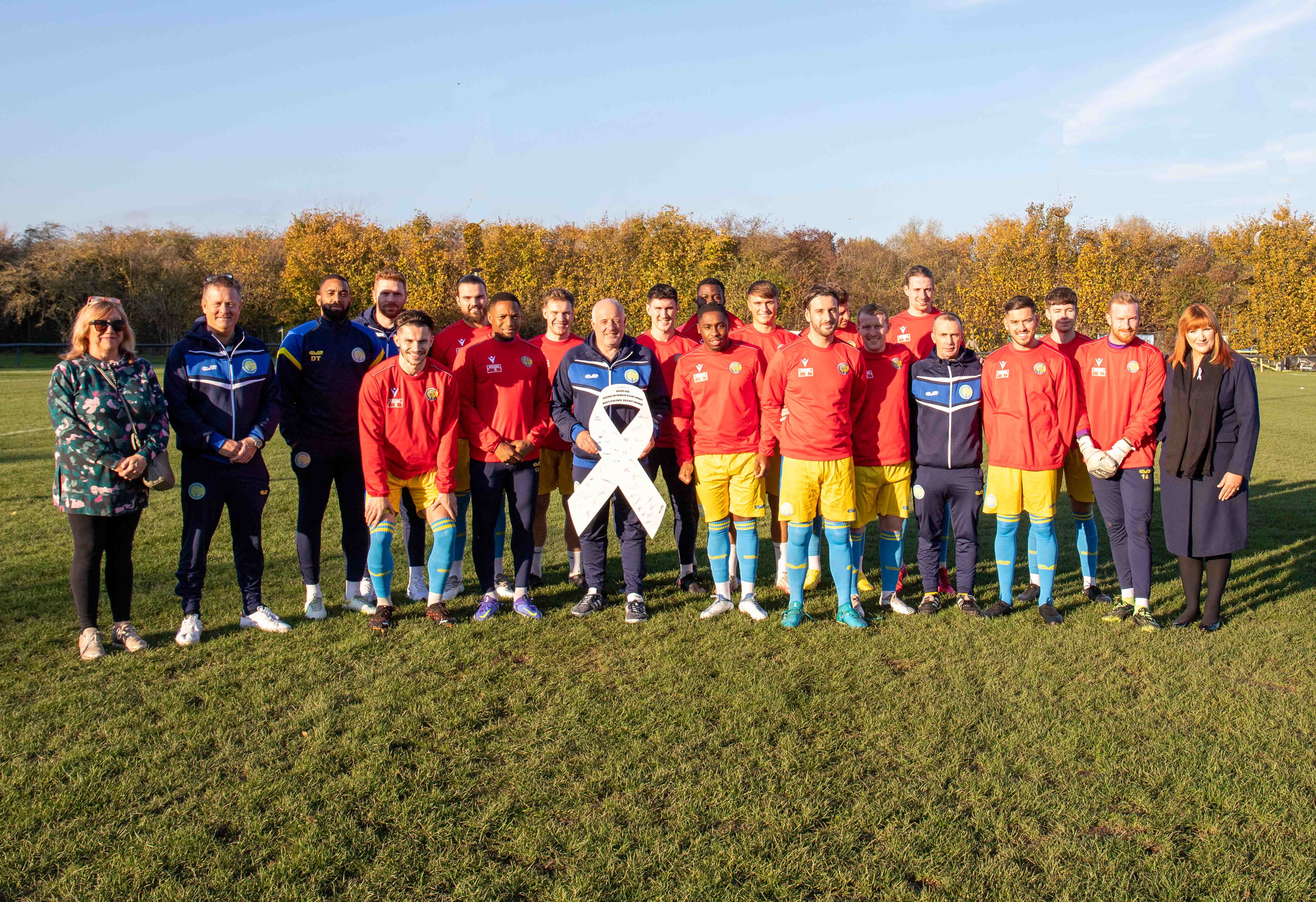 Full squad on pitch with councillors holding white ribbon